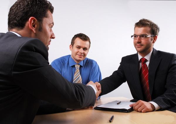 job candidate and two interviewers are talking at a bank